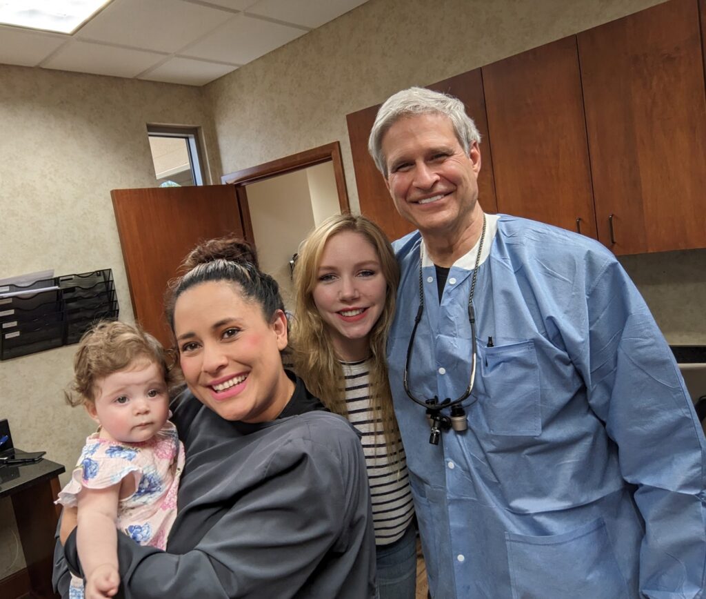 Dr. Pierson posing with patients and an employee at Derby Dental Care, showcasing the clinic's community.