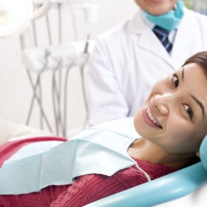 Female patient smiling in the exam chair at Derby Dental Care, receiving personalized dental treatment.